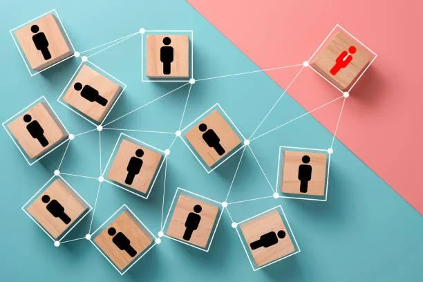 Wooden blocks connected by lines representing a network of HR relationships with a standout candidate